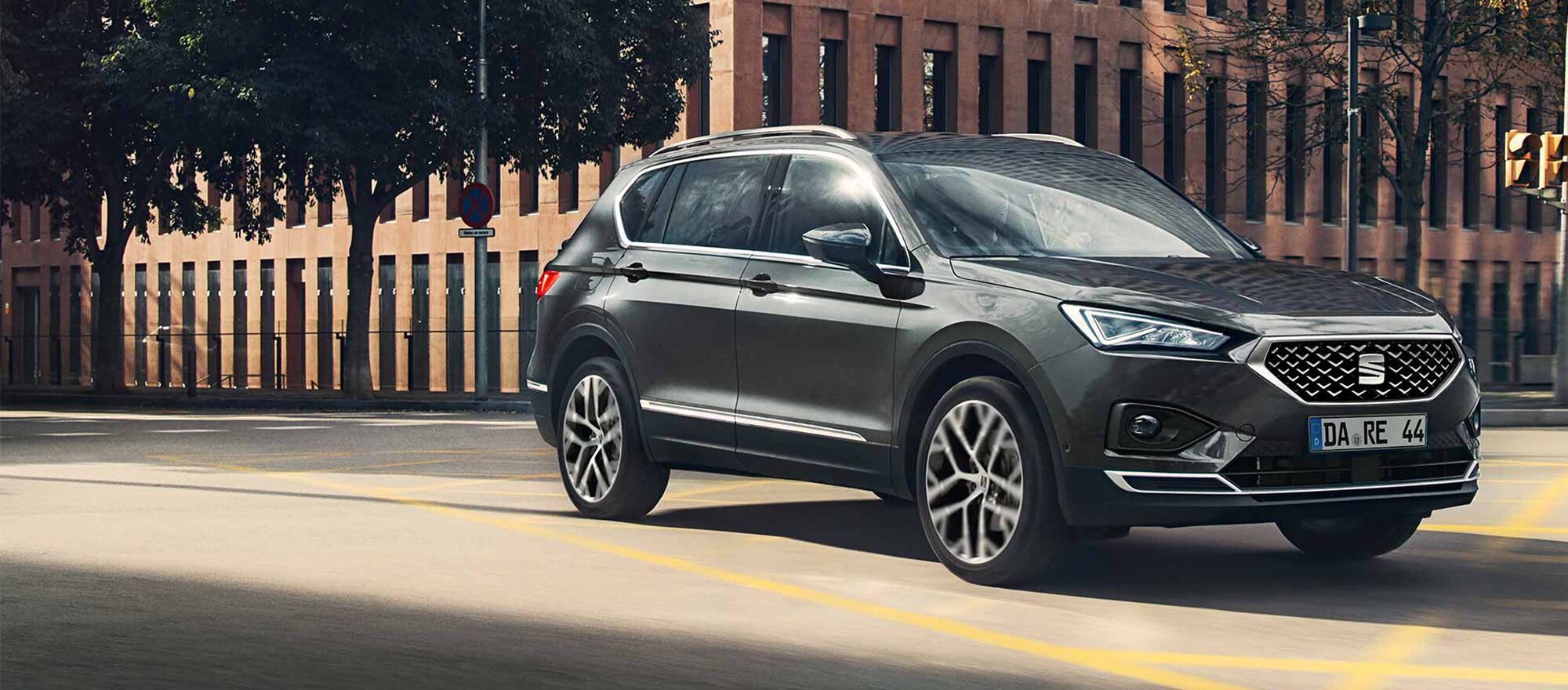 Der SEAT Tarraco fährt vor einem großen Gebäude entlang