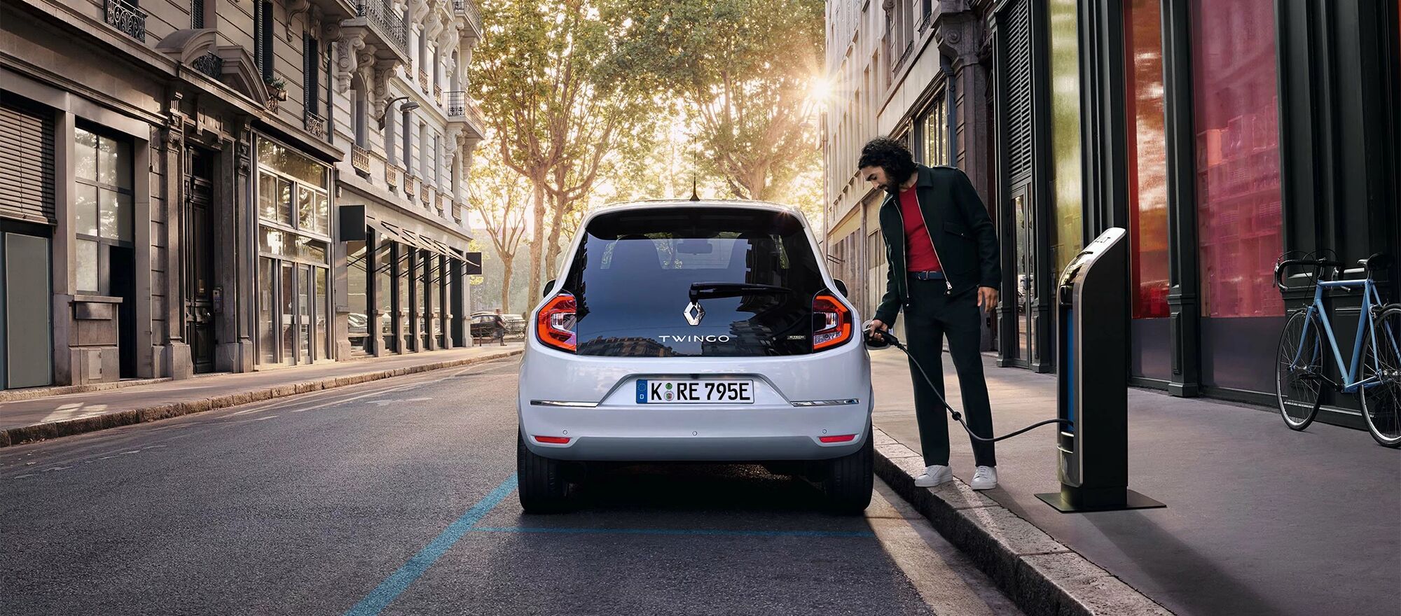 Ein Mann lädt seinen Renault Twingo E-Tech an einer kleinen Ladesäule