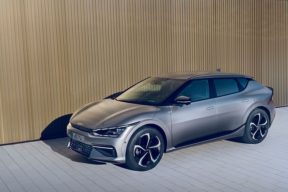 Ein parkender Kia EV6 vor einer Holzwand im seitlichen Profil