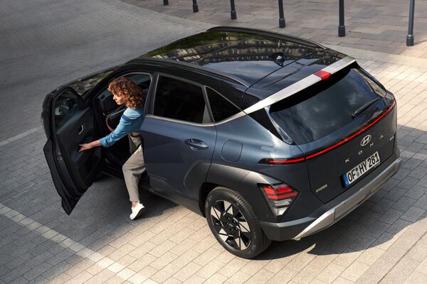 Ein Frau steigt aus einem parkenden Hyundai KONA aus