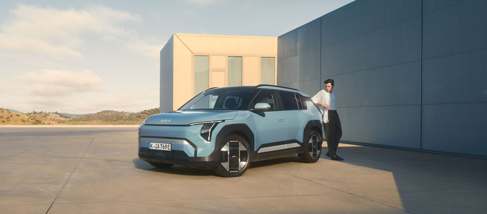 Ein Mann lehnt sich an einen parkenden Kia EV3