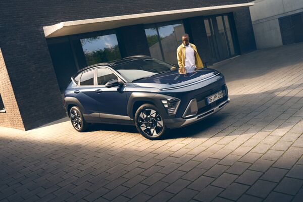 Ein Mann steht hinter einem parkenden Hyundai KONA