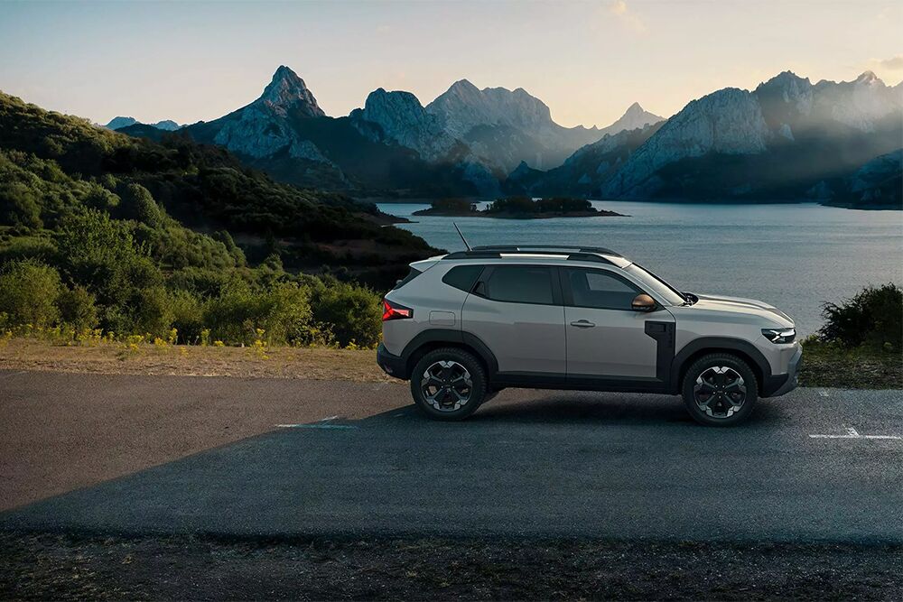 Der Dacia Duster steht seitlich vor einem See