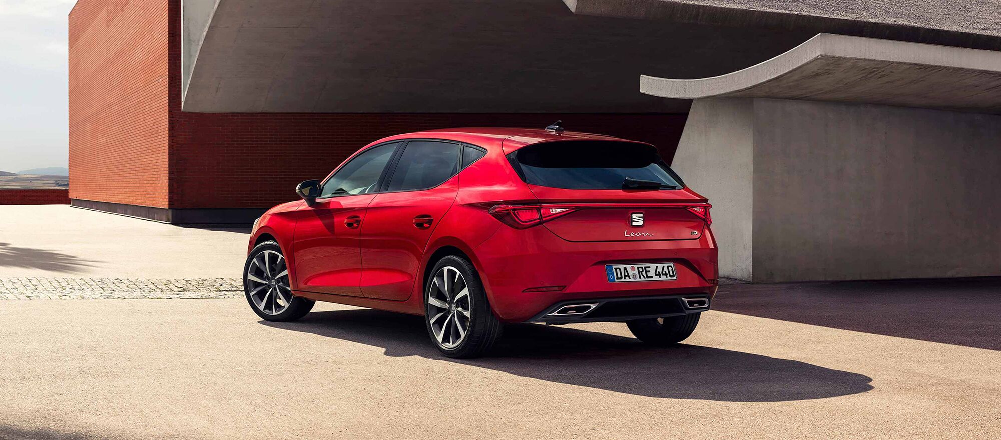 Ein SEAT Leon parkt vor einem Betongbebäude