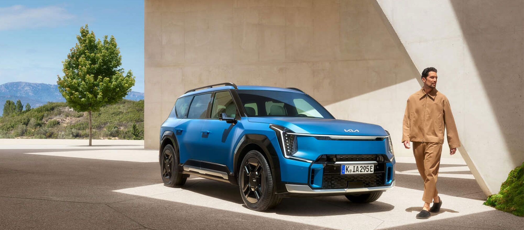 Ein Mann läuft an der Front des Kia EV9 vorbei