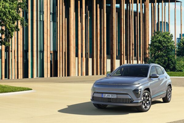 Der Hyundai KONA Elektro parkt vor einem Holzgebäude