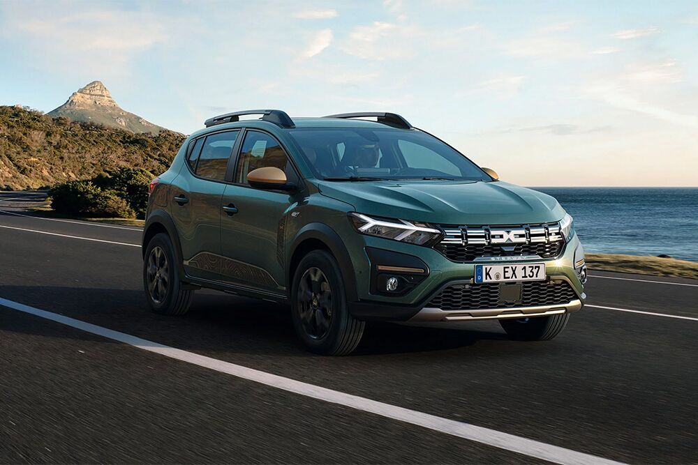 Ein fahrender Dacia Sandero Stepway vor dem Meer
