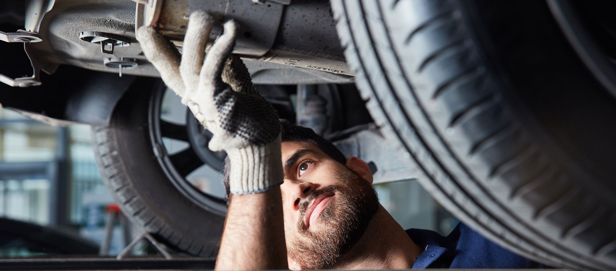 Ein Mechaniker arbeitet unter einem Auto