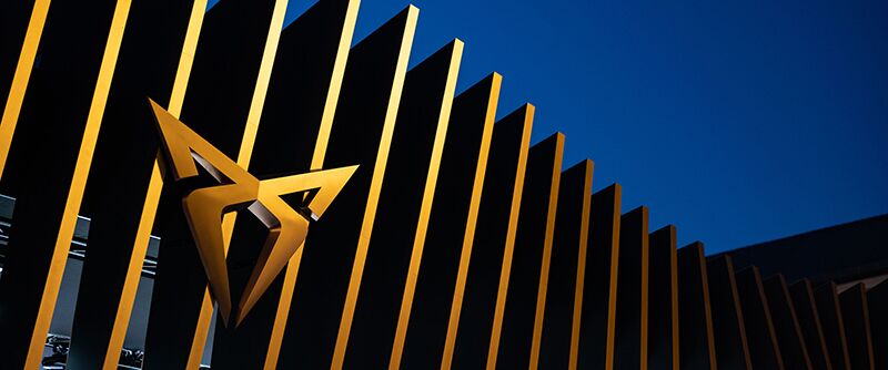 Ein CUPRA Logo auf einem bronzefarbenen Zaun