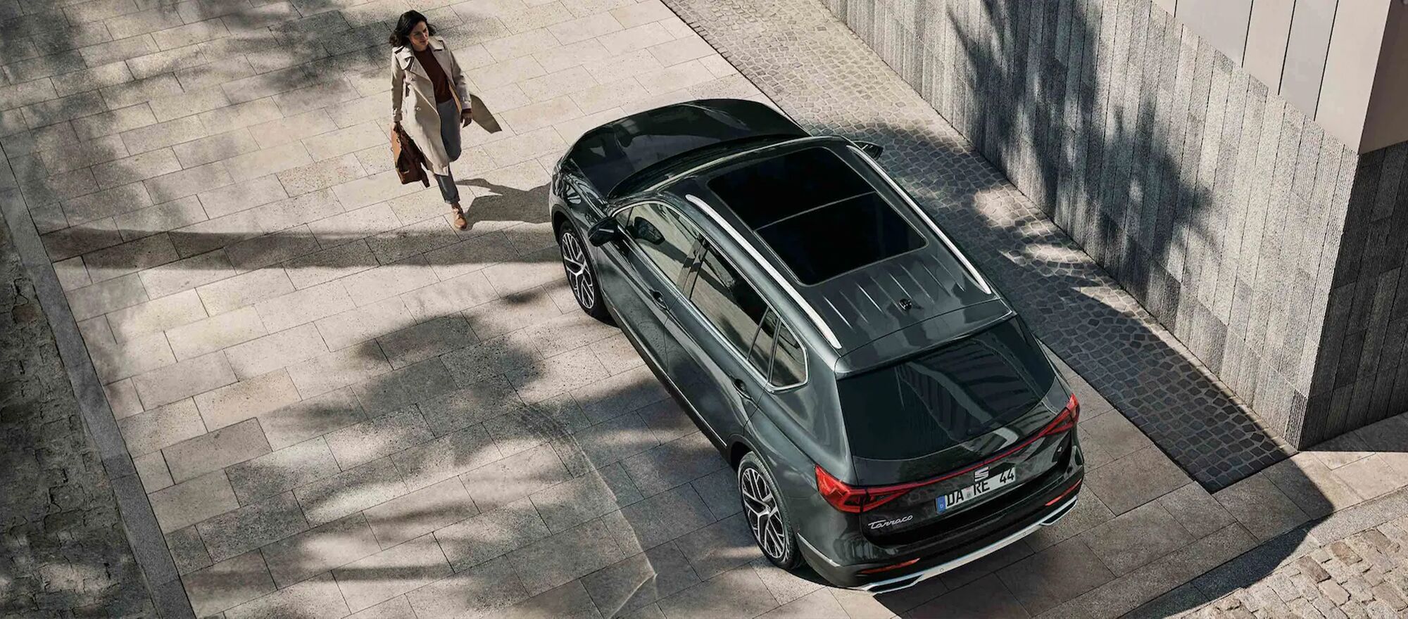 Eine Frau läuft auf einen SEAT Tarraco zu