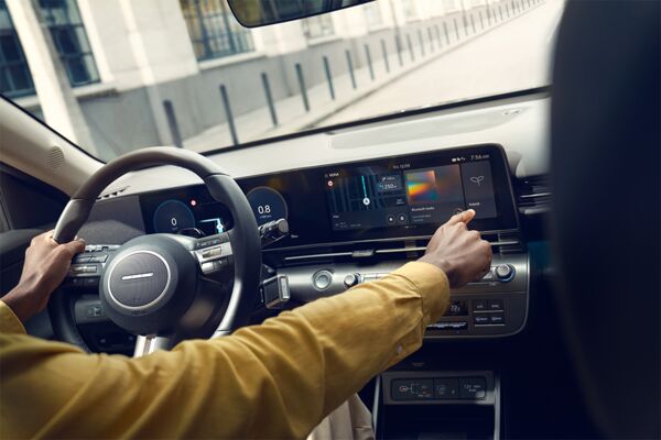Ein Person mit gelber Jacke bedient den Display im Hyundai KONA