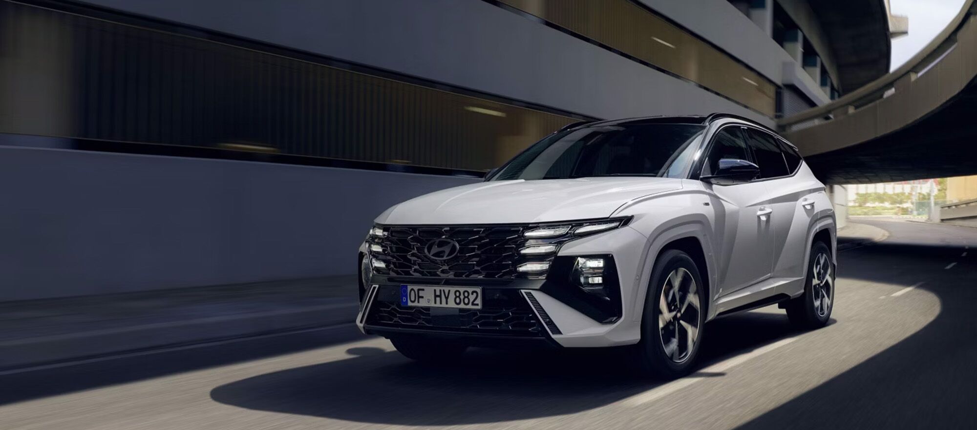 Nahaufnahme eines Hyundai TUCSON wie er durch eine Kurve fährt