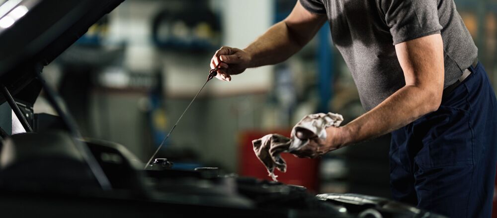 Ein Mechaniker putzt den Ölprüfstand mit einem Handtuch