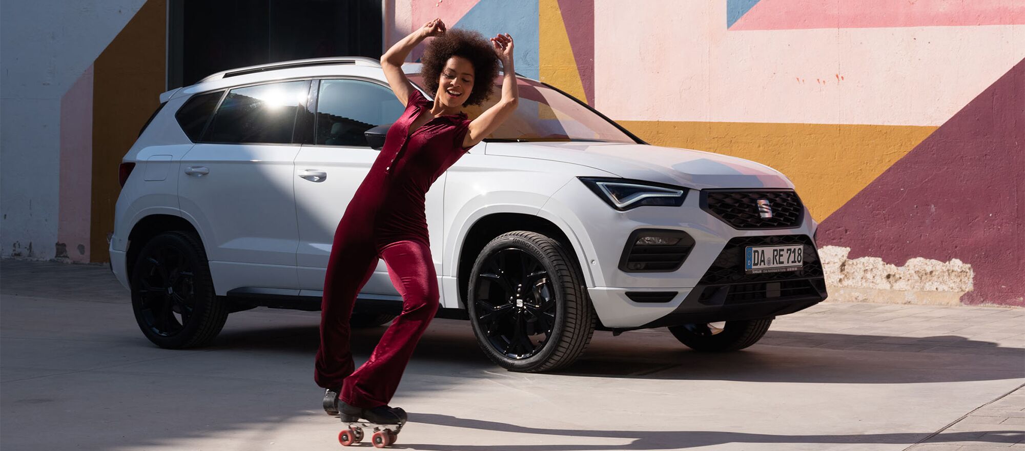 Eine Frau fährt auf Rollerblades und im Hintergrund steht ein SEAT Arona