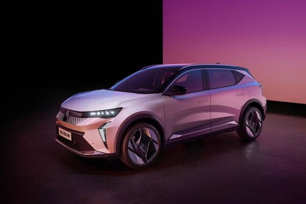 Der Renault Scenic E-Tech mit leuchtenden Lichtern vor einer lilafarbenen Wand