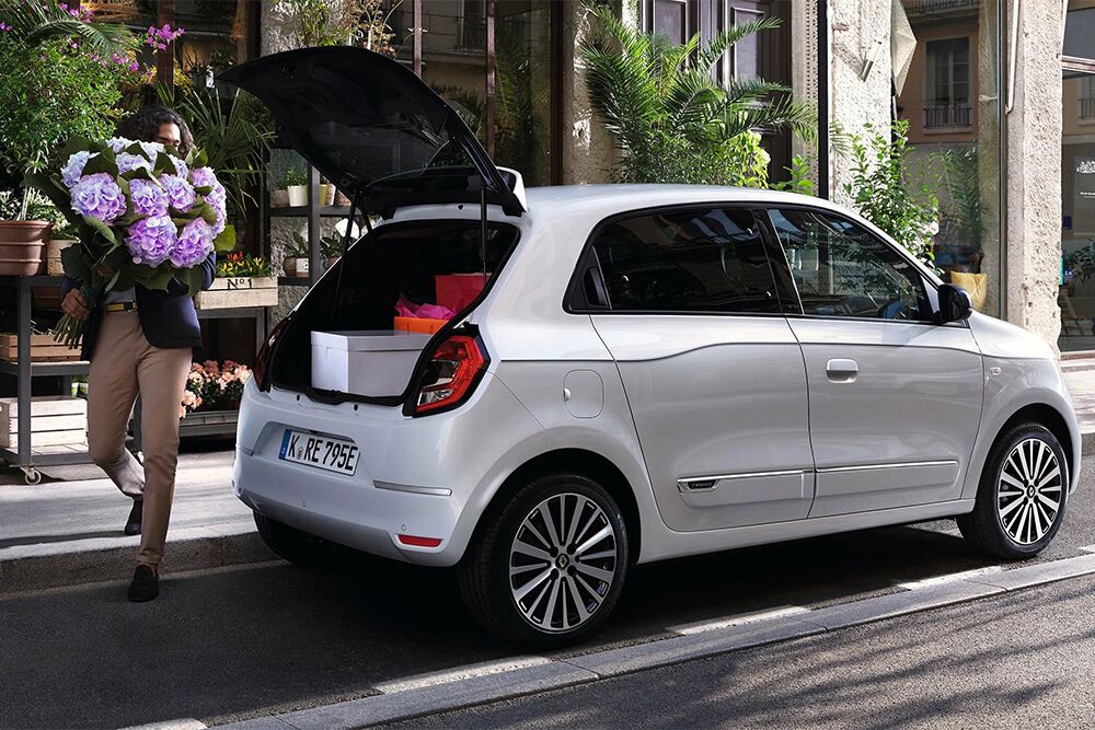 Ein Mann lädt Blumen in den Kofferraum des Renault Twingo E-Tech