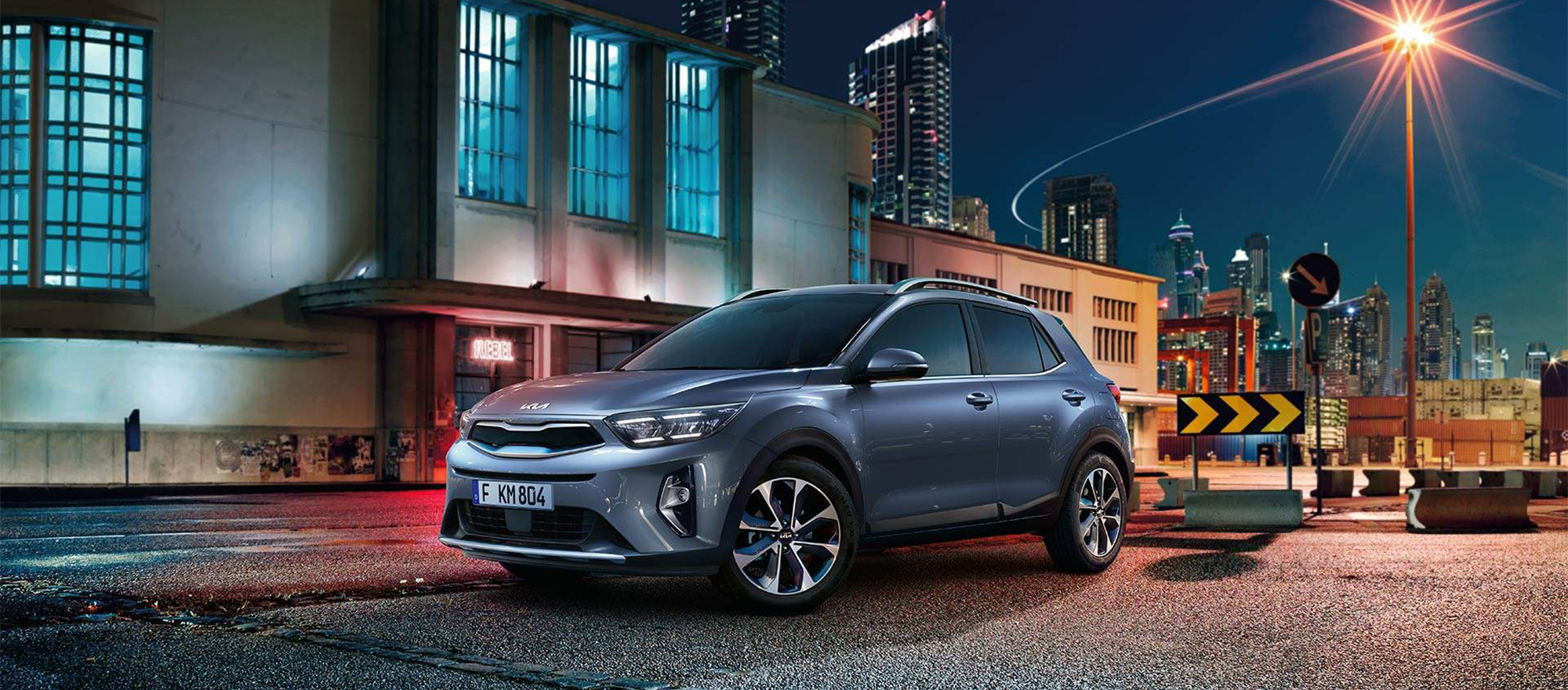 Der Kia Stonic steht Nachts vor einem alten Gebäude