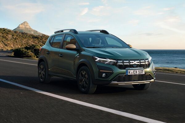 Ein fahrender Dacia Sandero Stepway vor dem Meer