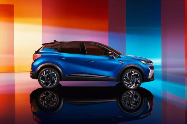Eine seitliche Ansicht auf den Renault Captur vor einem bunten Hintergrund