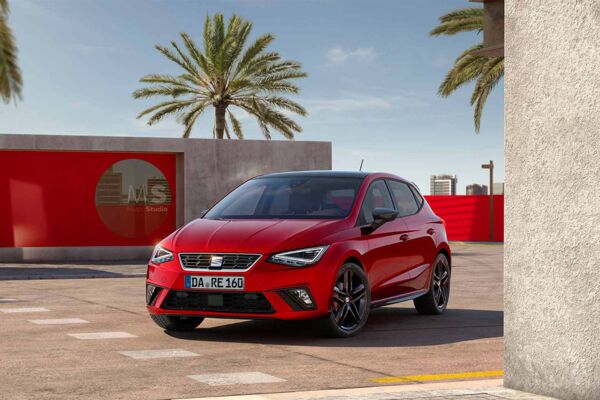 Ein SEAT Leon steht auf einem Platz und im Hintergrund stehen Palmen